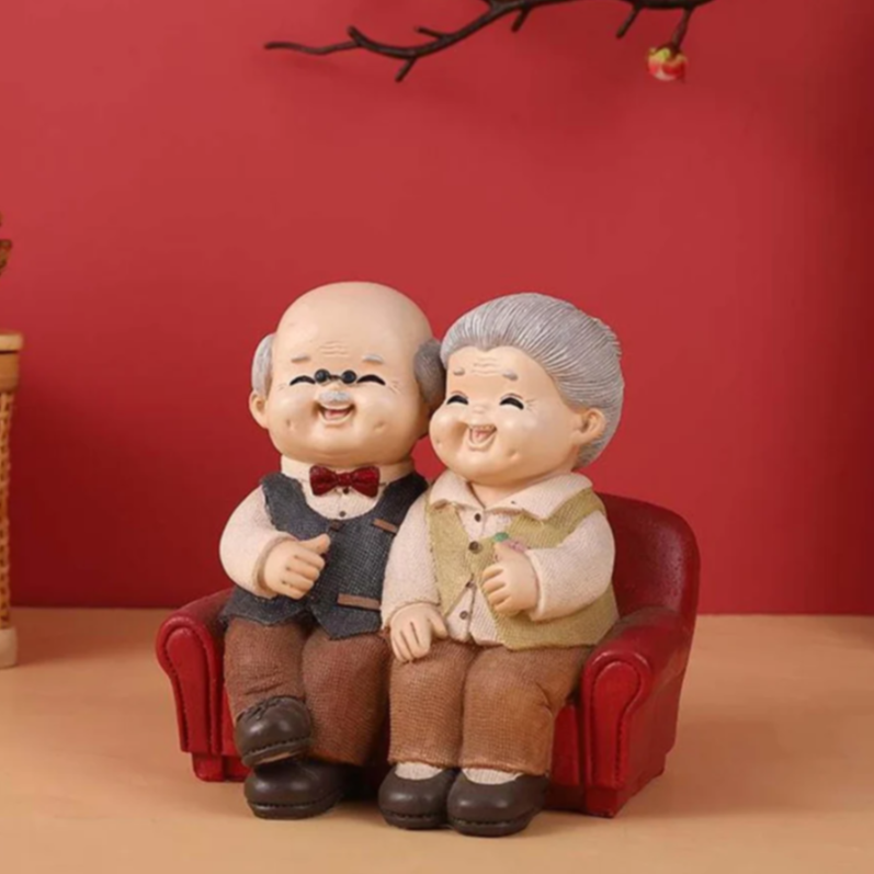 Elderly couple figurine on red sofa