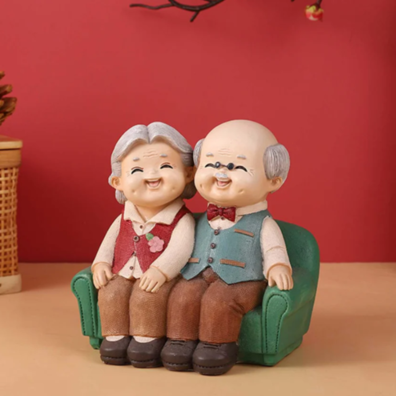 Elderly couple figurine on green sofa forever together